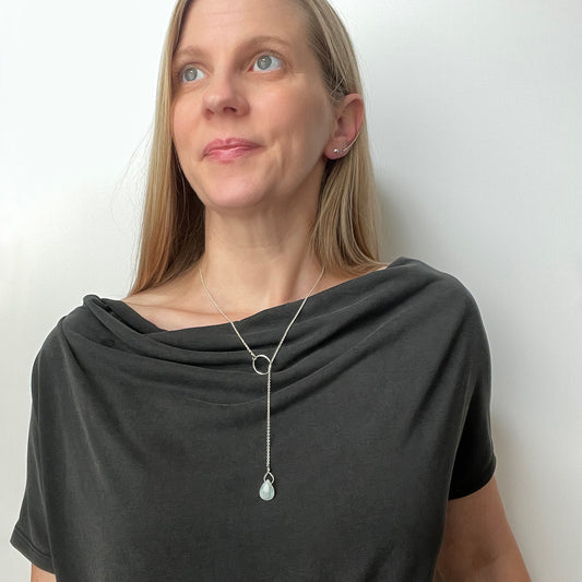 woman wearing an aquamarine teardrop lariat style necklace