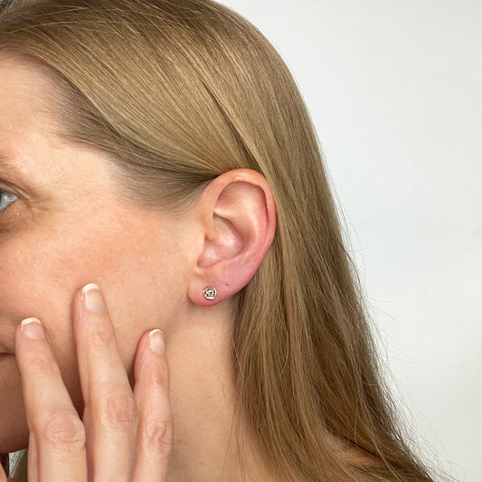 woman wearing silver twisted knot stud earrings