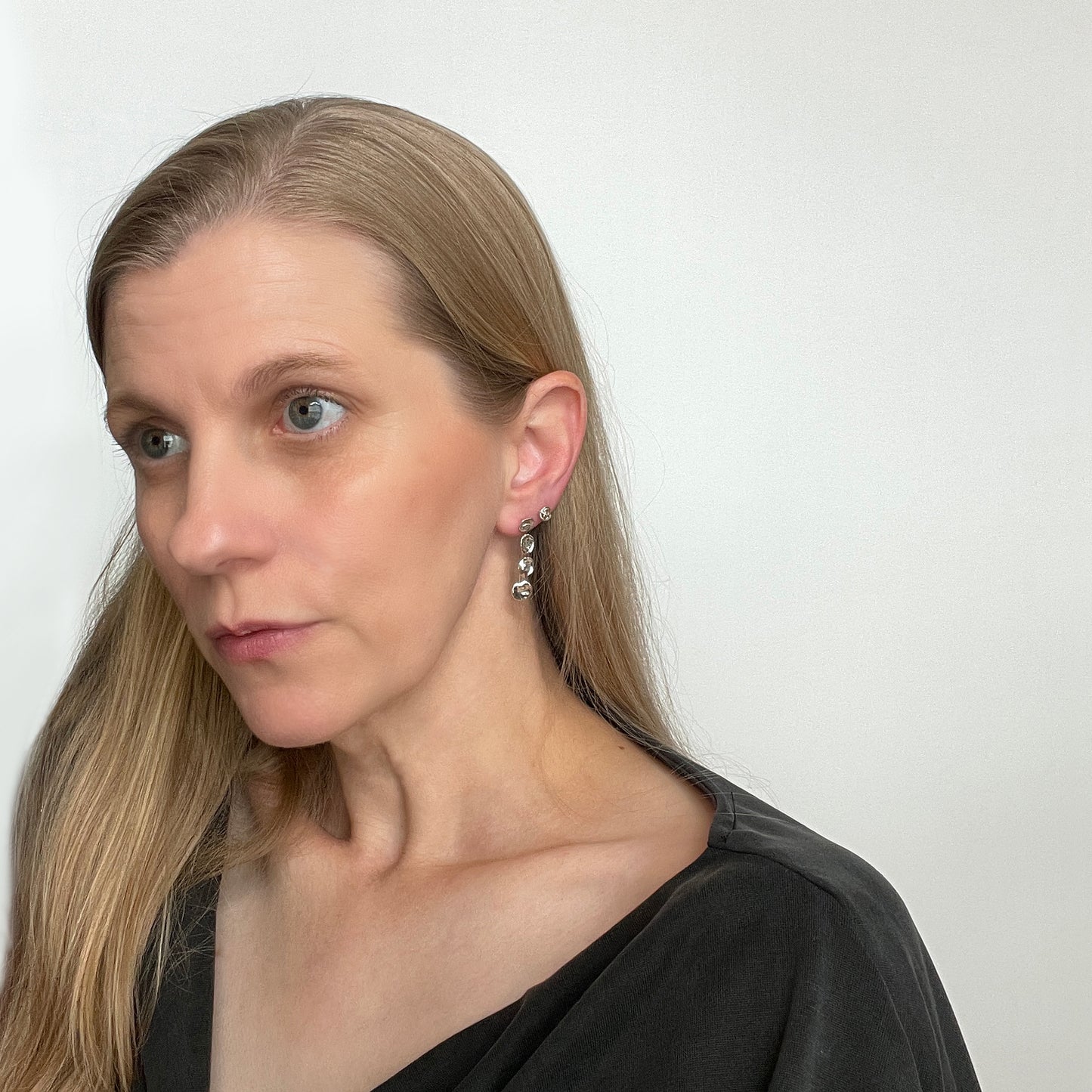 woman wearing silver water drop earrings