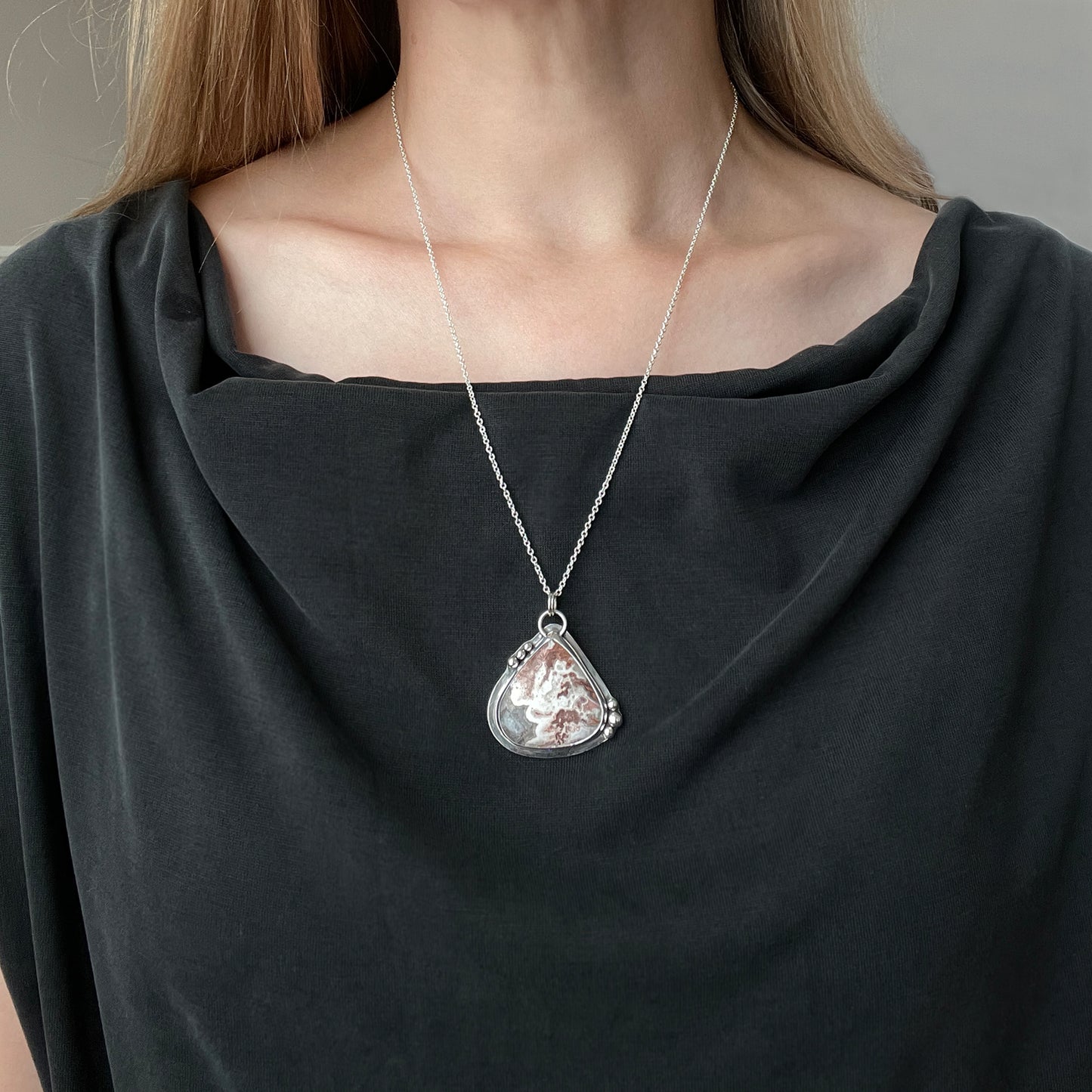 woman wearing a silver and agate pendant necklace