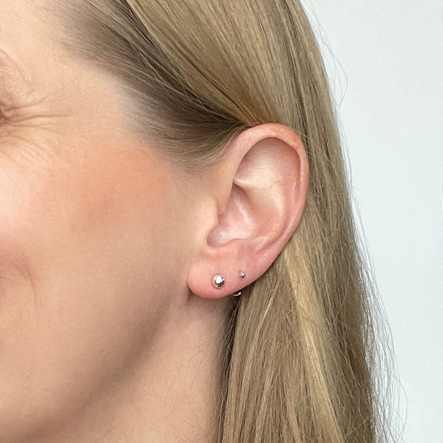 woman wearing silver ball stud earrings